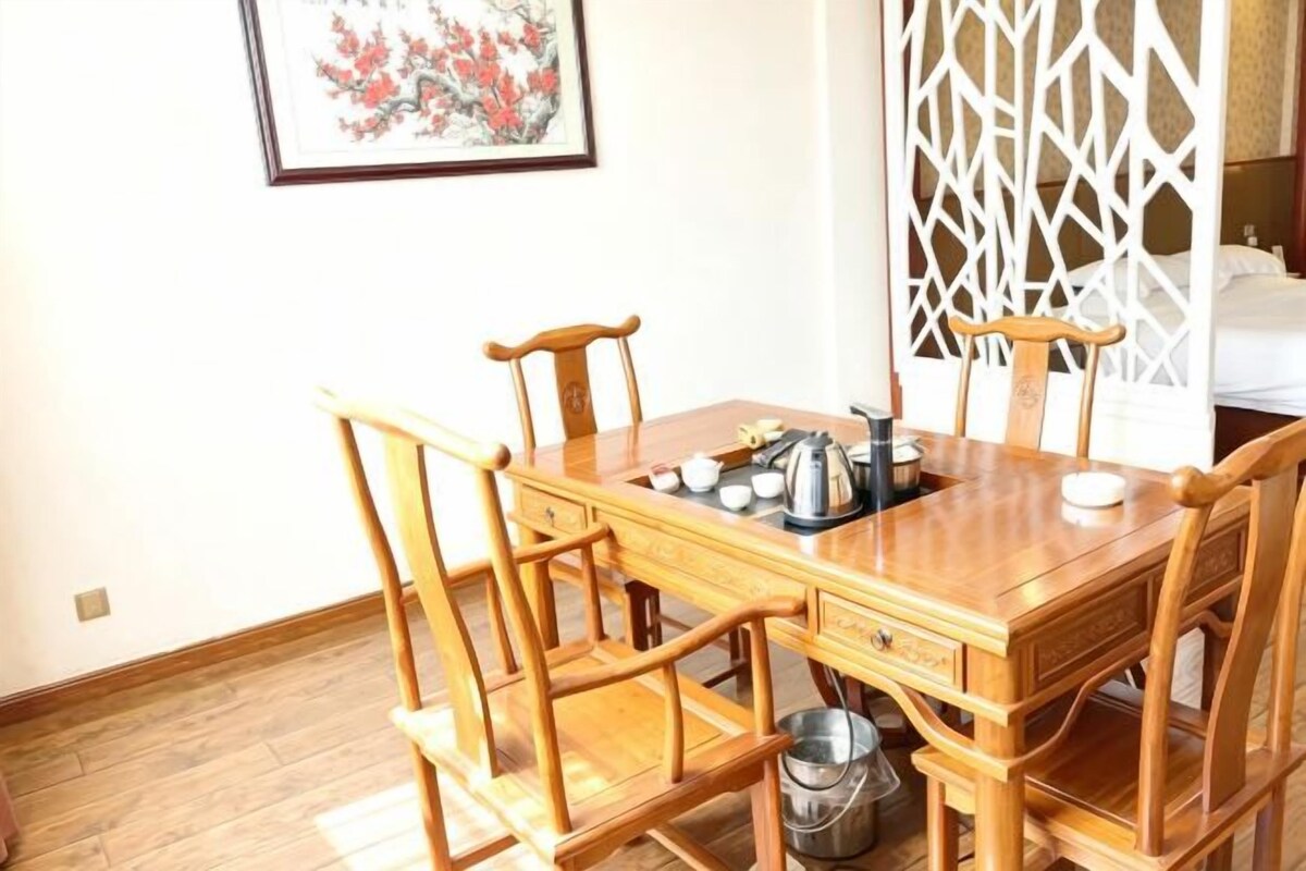 Una mesa de madera con sillas, una tetera y un hervidor sobre la mesa.