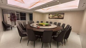 A modern dining area with a round table, eight chairs, and a ceiling with a light display. - Jinqiu Courtyard Hotel (Shaowu)