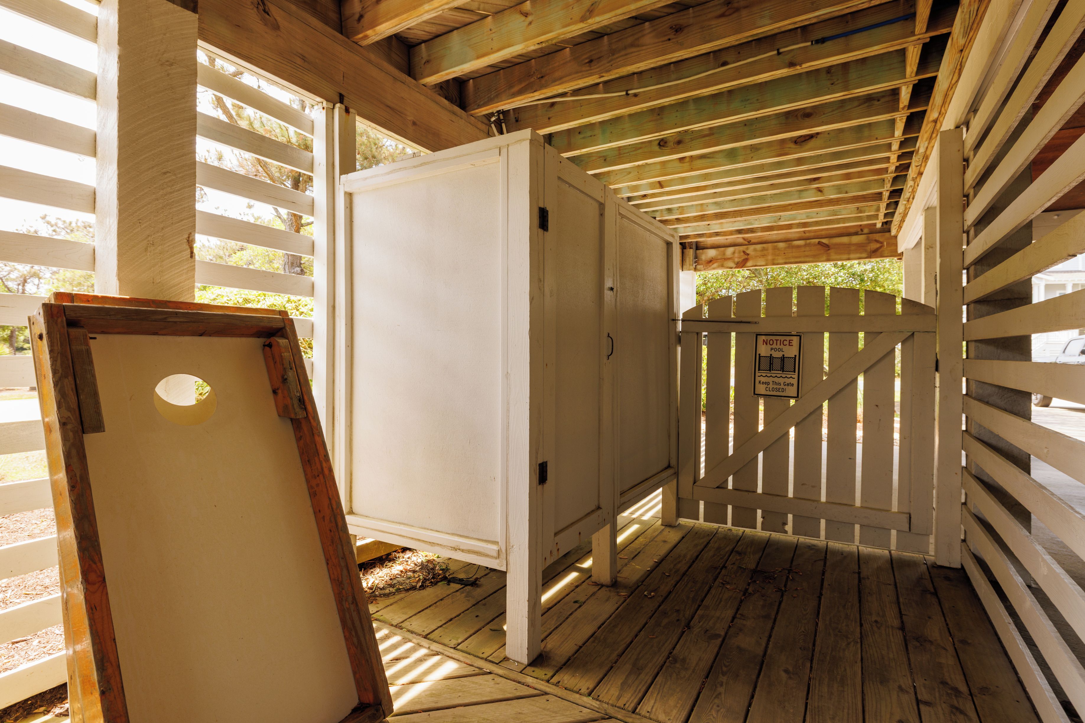 A wooden structure with a white door and a notice sign.