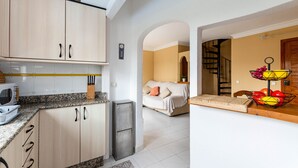 A modern kitchen with granite countertops, wooden cabinets, and a built-in microwave. - Yourhouse El Xiprer (Pollensa)