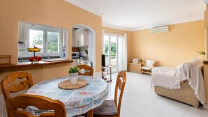 A cozy living area with a dining table, chairs, a sofa, and a kitchen in the background. - Yourhouse El Xiprer (Pollensa)