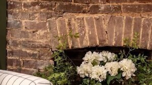 A cozy living room with a brick fireplace, a white sofa, and a decorative vase with flowers. - “Bourbon Trail Beauty” (Lawrenceburg)