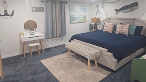 A bedroom with a bed, a bedside table, a mirror, a window with curtains, and wall art. - Vacation home near the beaches!. (Pocomoke City)