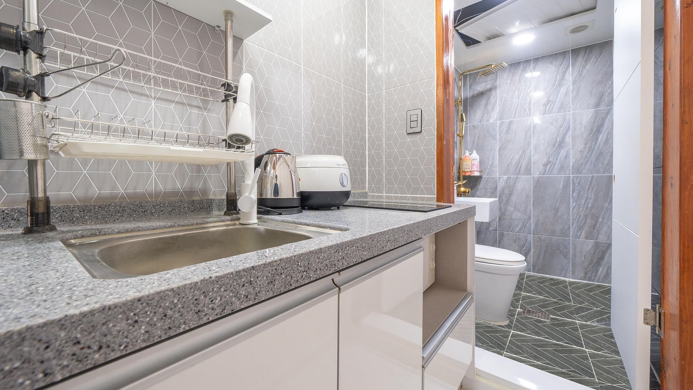 A modern bathroom with a sink, toilet, and shower area.
