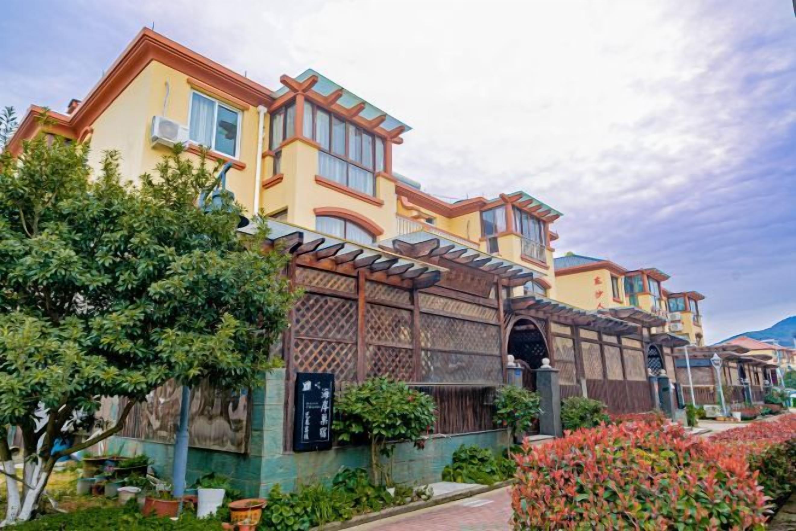 Ein mehrstöckiges Hotel im traditionellen Baustil, mit Balkonen und einem überdachten Gang.