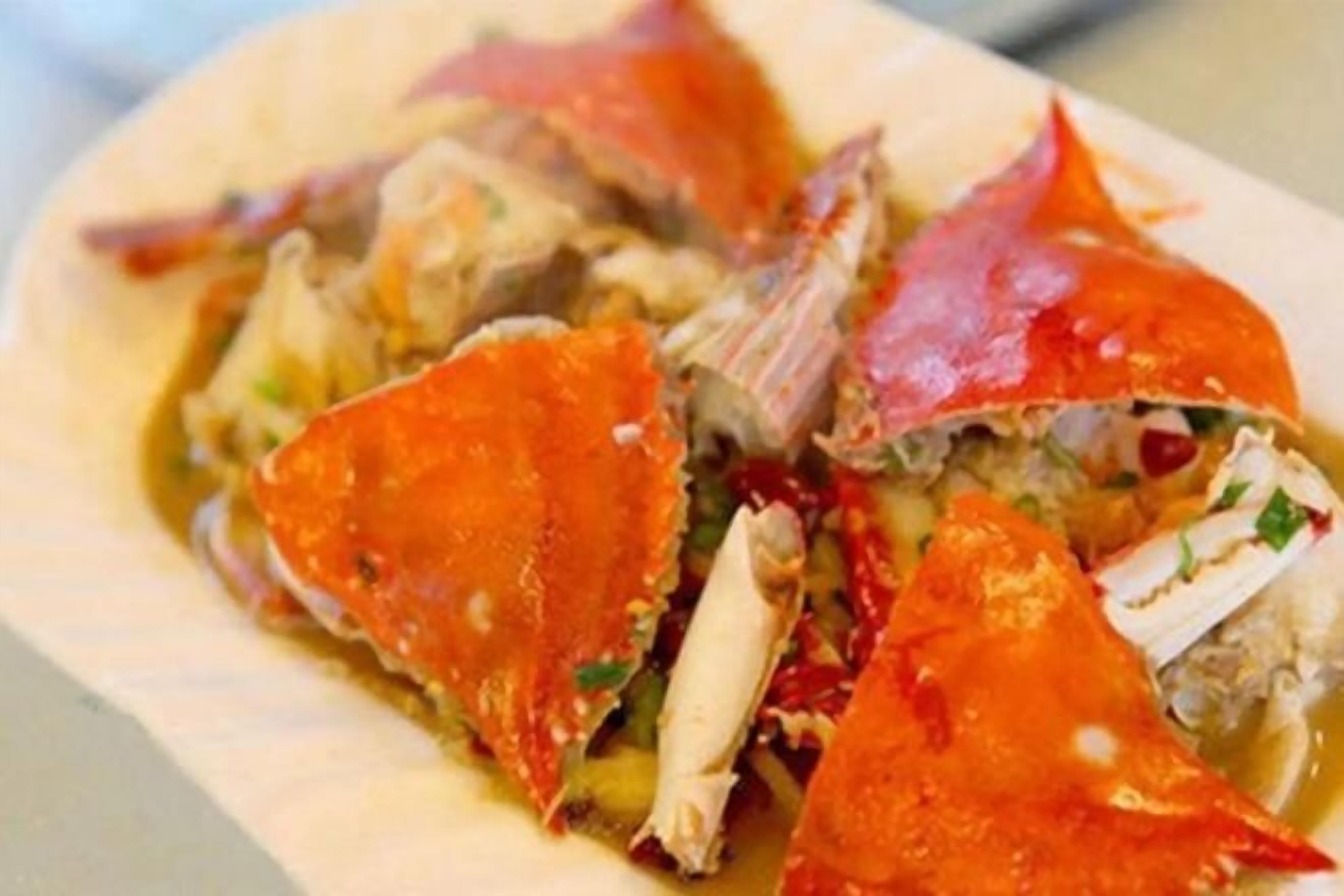 A crab dish with a red shell and white meat, served on a plate.