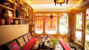 A traditional wooden interior with a sofa, shelves, and a dining table. - Juxian Boutique Homestay（South Gate of Ancient City） (Lijiang)