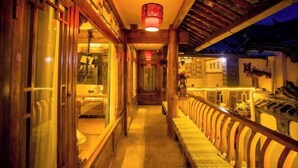 A corridor with wooden railings, a bench, and a hanging lantern. - Juxian Boutique Homestay（South Gate of Ancient City） (Lijiang)
