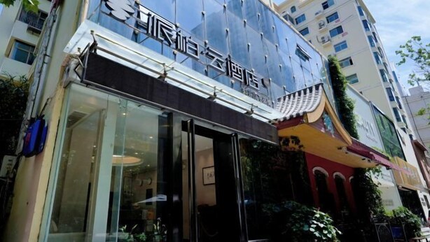 A hotel with a modern glass facade and traditional architectural elements.