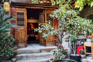 Un edificio tradicional de madera con una escalera de piedra que lleva a una puerta.