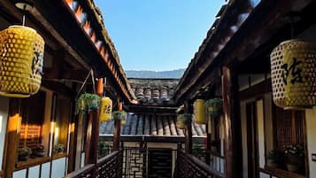 Um corredor japonês tradicional com balaústres de madeira e lanternas suspensas.