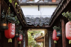 A narrow alleyway with traditional tiled roofs and hanging red lanterns. - Chenjia Courtyard (Guangyuan)