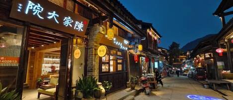 A traditional street with shops and a restaurant with a sign in a foreign language.
