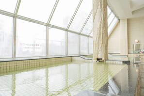 A large indoor swimming pool with clear glass walls, tiled floor, and a modern design. - Asahi Sauna Capsule Inn Hirosaki (Hirosaki)