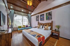 A spacious bedroom with a large bed, wooden ceiling, and artwork on the walls. - Old Town of Lijiang Big Waterwheel · Yimeng Chenfeng Rizhao Jinshan Snow Mountain Scenic Inn (Lijiang)