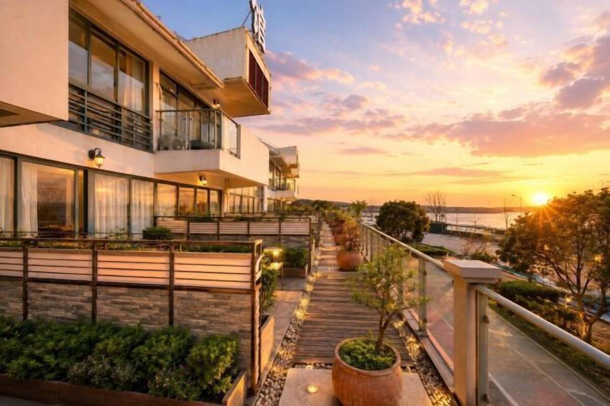 Ein modernes Hotel mit Balkon, Sitzgelegenheit im Freien und Blick auf den Sonnenuntergang.