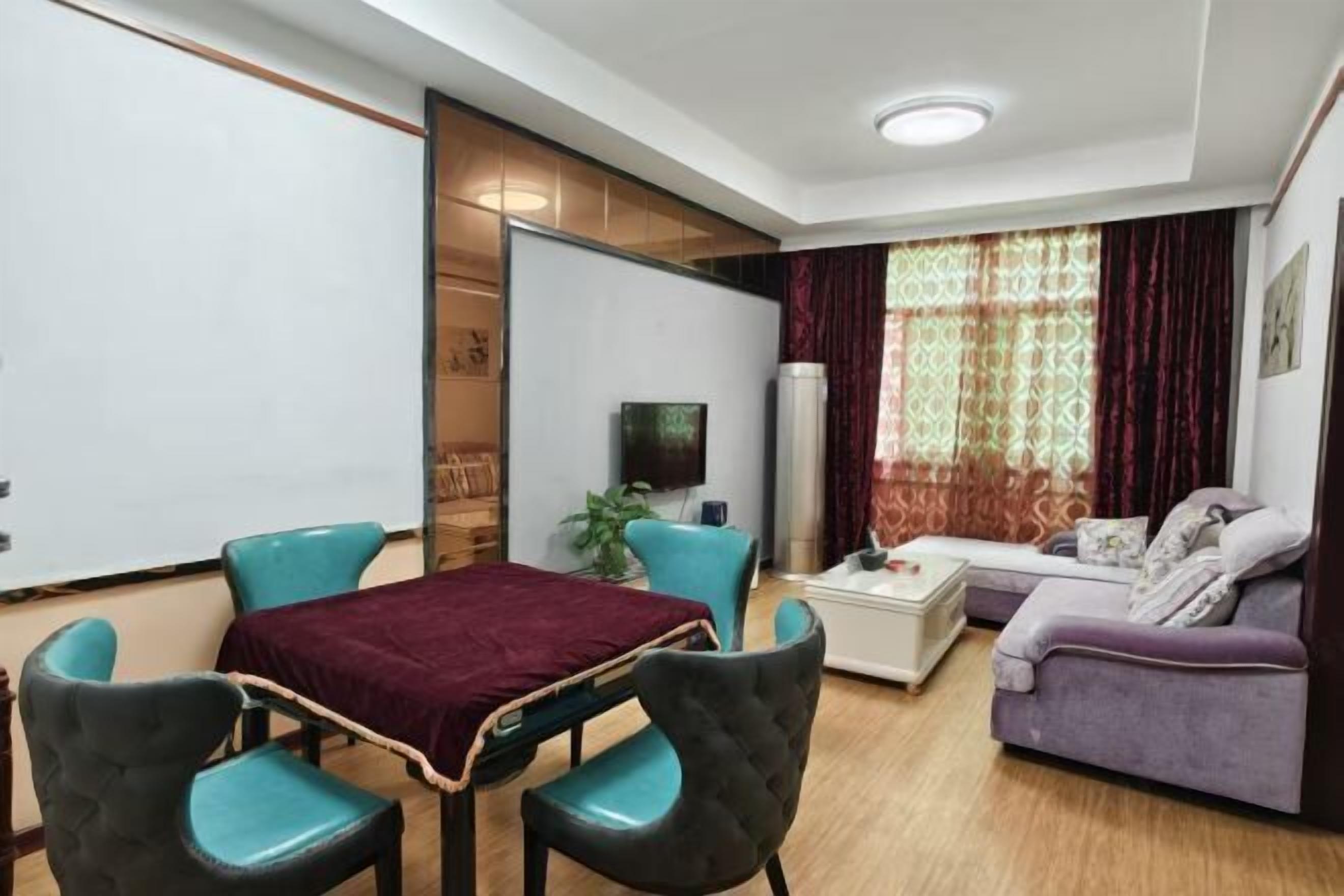 Uma sala de estar moderna com um sofá, duas poltronas, uma mesa de centro e uma televisão.