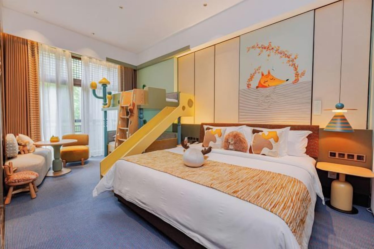A hotel room with a large bed, a staircase, and a wall mural.