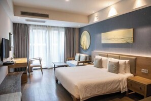 A modern hotel room with a large bed, a desk, a chair, and a TV. - Wuxi Nianhua Bay Polomydo Hotel, (Wuxi)