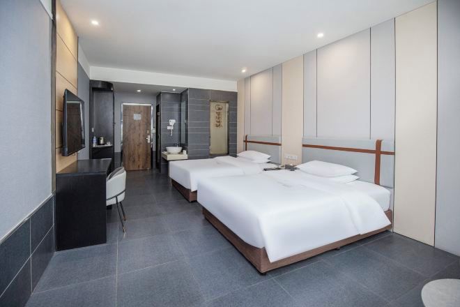 Una habitación de hotel moderna con una cama grande, un escritorio y una silla.