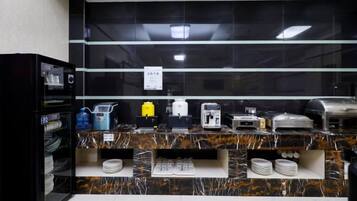 Ett modernt hotellrum med ett badrumsskåp i marmorimitation, en minibar och en kaffestation.