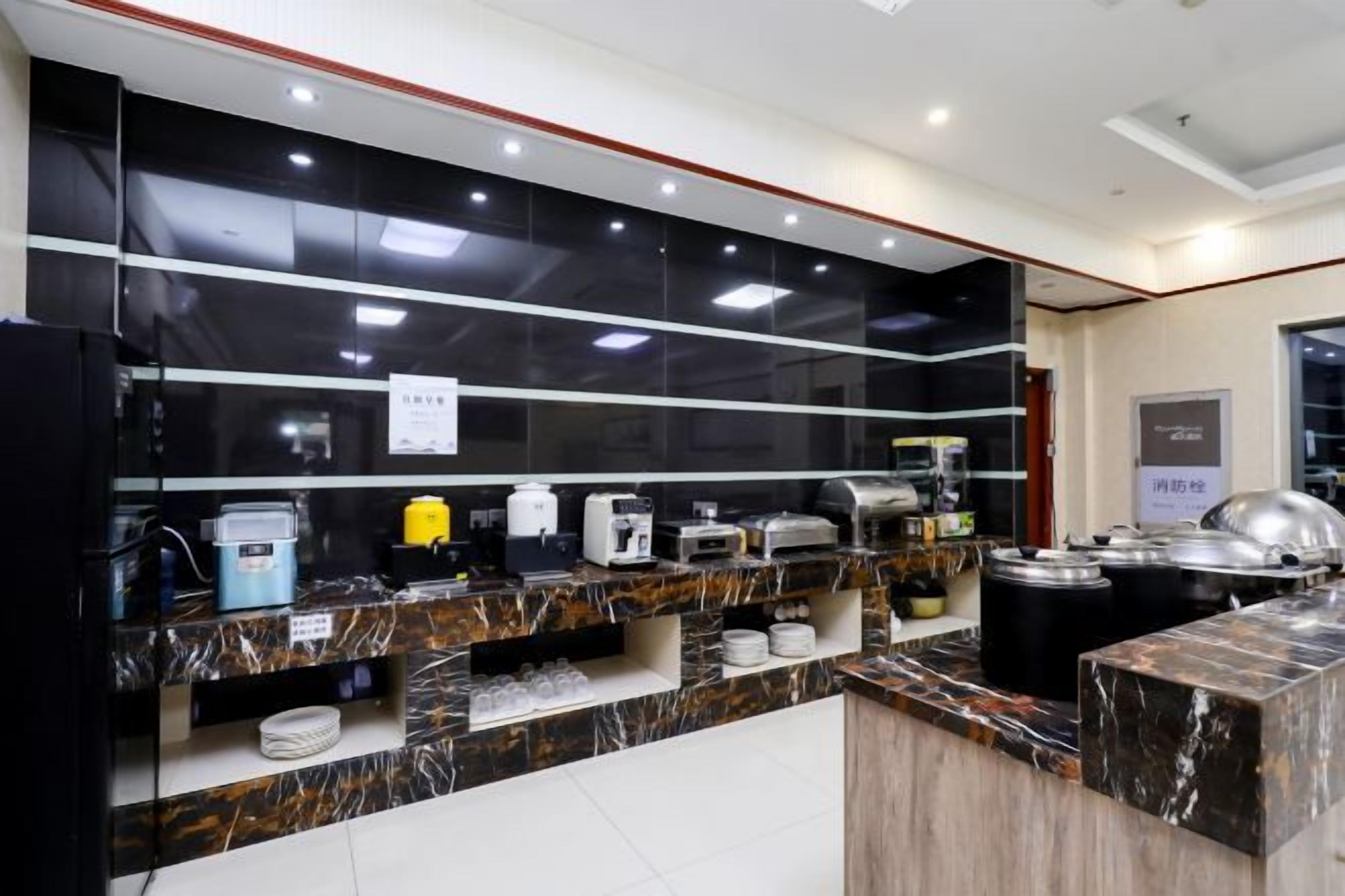 A modern kitchen with marble countertops, stainless steel appliances, and a black backsplash.