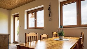 A dining area with a wooden table, chairs, and a potted plant.