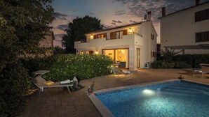 A two-story house with a swimming pool, outdoor seating, and a well-lit entrance. - Villa Mare With Private Pool And Garden, Malinska, Croatia (Malinska)
