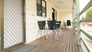 A covered porch with wooden flooring, metal chairs, and a small table. - House 3 BR with parking, Close to hospital 2.2km Red Energy Arena Bendigo 1.6 km (Golden Square)