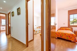 A bedroom with a wooden floor, a bed with an orange polka dot bedspread, and a window with a view of the outdoors. - 2MARINA01 - House with a private pool in a residencial area (Blanes)