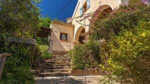 Una escalera de piedra que conduce a un edificio de ventanas arqueadas y fachada rústica.