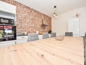 Enjoy meals in this spacious kitchen with an oven, refrigerator, and range hood.