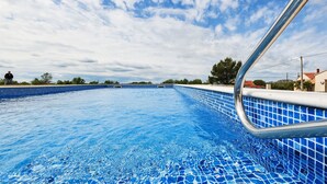 Ein Schwimmbecken mit klarem, blauem Wasser und einer gefliesten Kante.