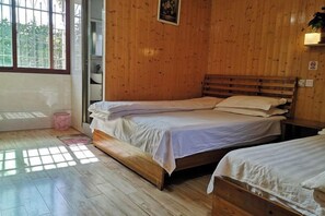 A room with two wooden beds, a window, and a door. - Fangyuan Inn (Nanjing County)