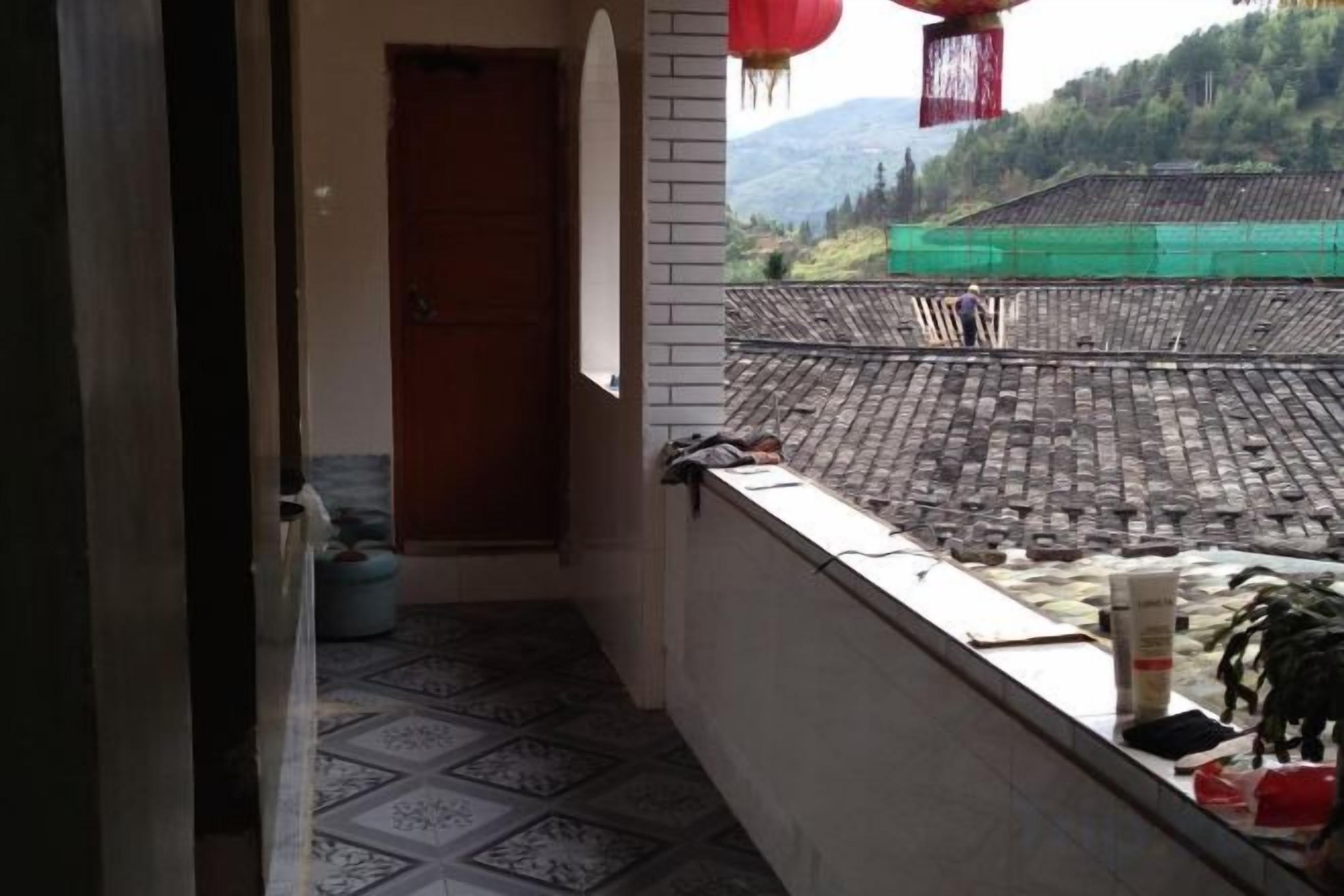 Ein Balkon mit Blick auf ein traditionelles Gebäude und Berge.