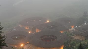 Un conjunto de edificios con techos circulares, ventanas visibles y luces, rodeado de follaje.