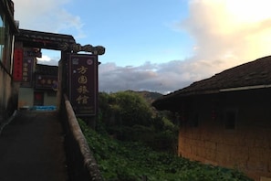 A narrow pathway leading to a traditional building with signage indicating a cultural or historical site. - Fangyuan Inn (Nanjing County)