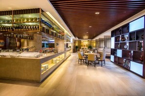 Un interior moderno con una zona de bar, asientos y estanterías.
