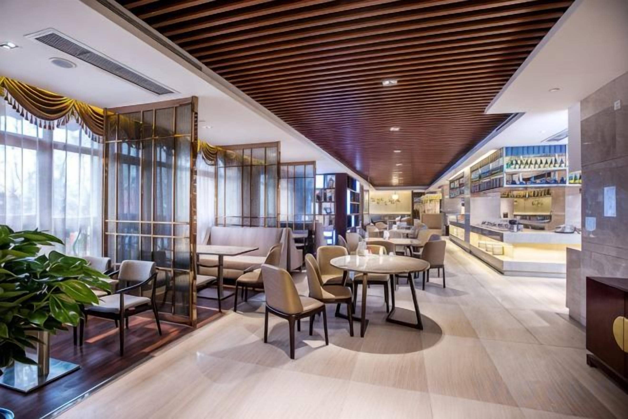 A modern interior with seating areas, a bar, and a view of the city.