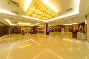 A spacious lobby with a high ceiling, a reception desk, and a modern chandelier. - Dahe International Hotel (Zhengzhou East Railway Station) (Zhengzhou)