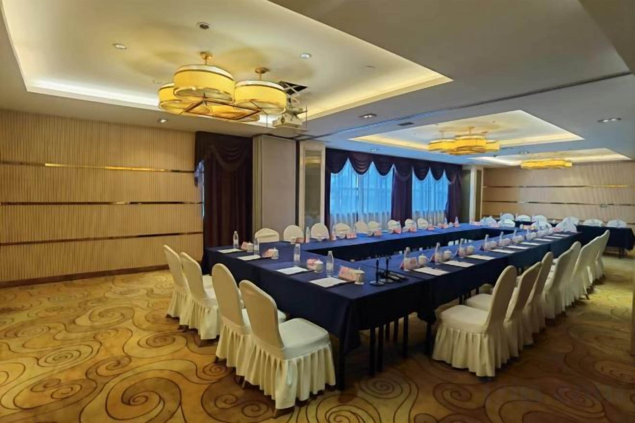 A conference room with a long table, chairs, and a chandelier.
