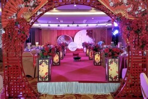 A stage with a red carpet, floral decorations, and a backdrop with a circular design. - Dahe International Hotel (Zhengzhou East Railway Station) (Zhengzhou)