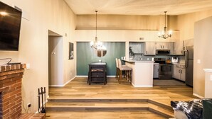 A modern kitchen with a central island, built-in appliances, and a dining area with chairs. - Cozy Lakeview Condo - 60 Day Special (Littleton)