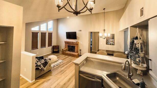 A spacious living area with a fireplace, a dining area, and a kitchen with a dishwasher. - Cozy Lakeview Condo - 60 Day Special (Littleton)
