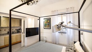 A modern bedroom with a bed, a desk, a chair, a TV, and a window with curtains. - Iommella luxury - Schifano (Sant´Agnello)