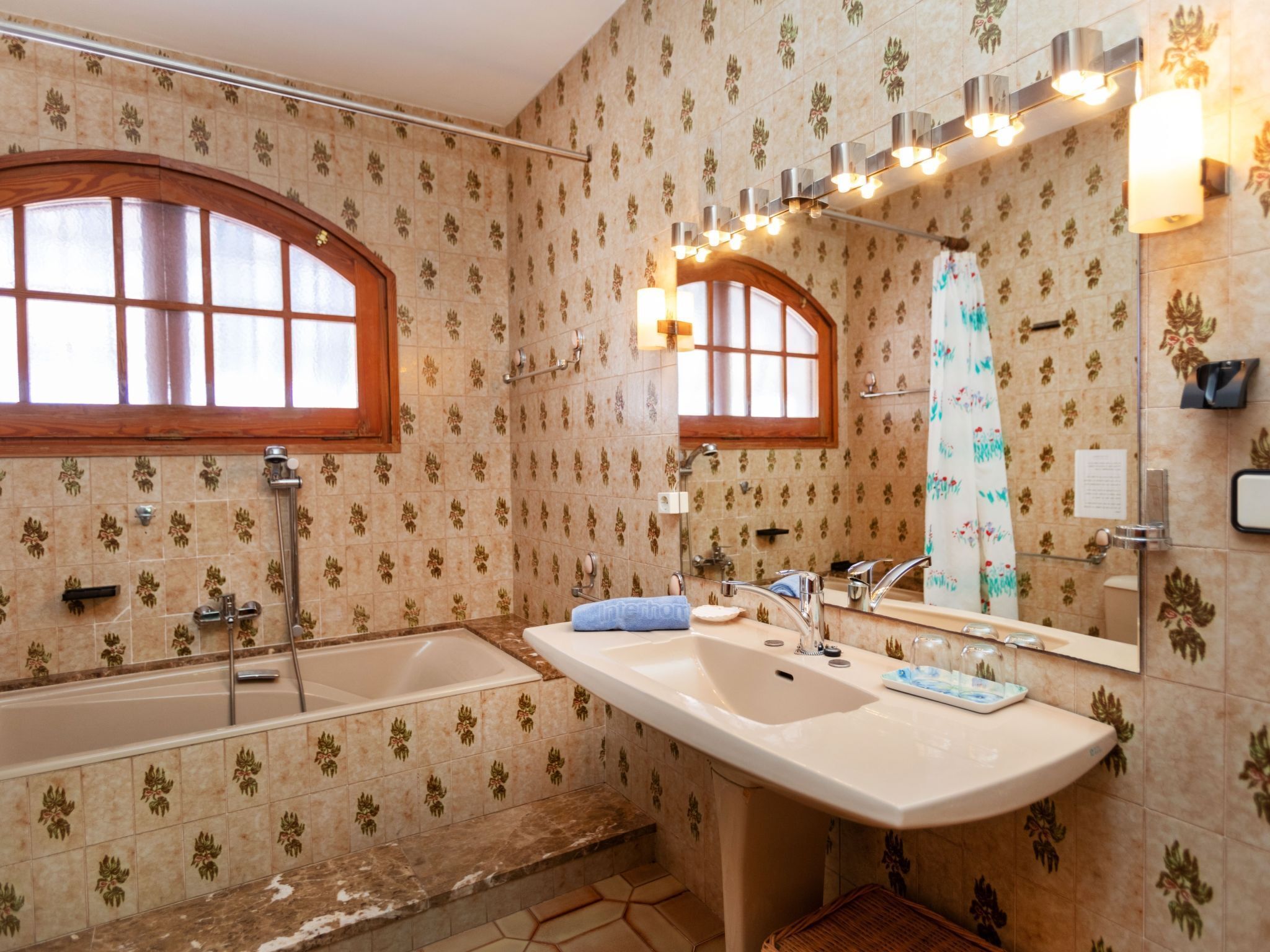 A bathroom with a bathtub, a sink, and a mirror.