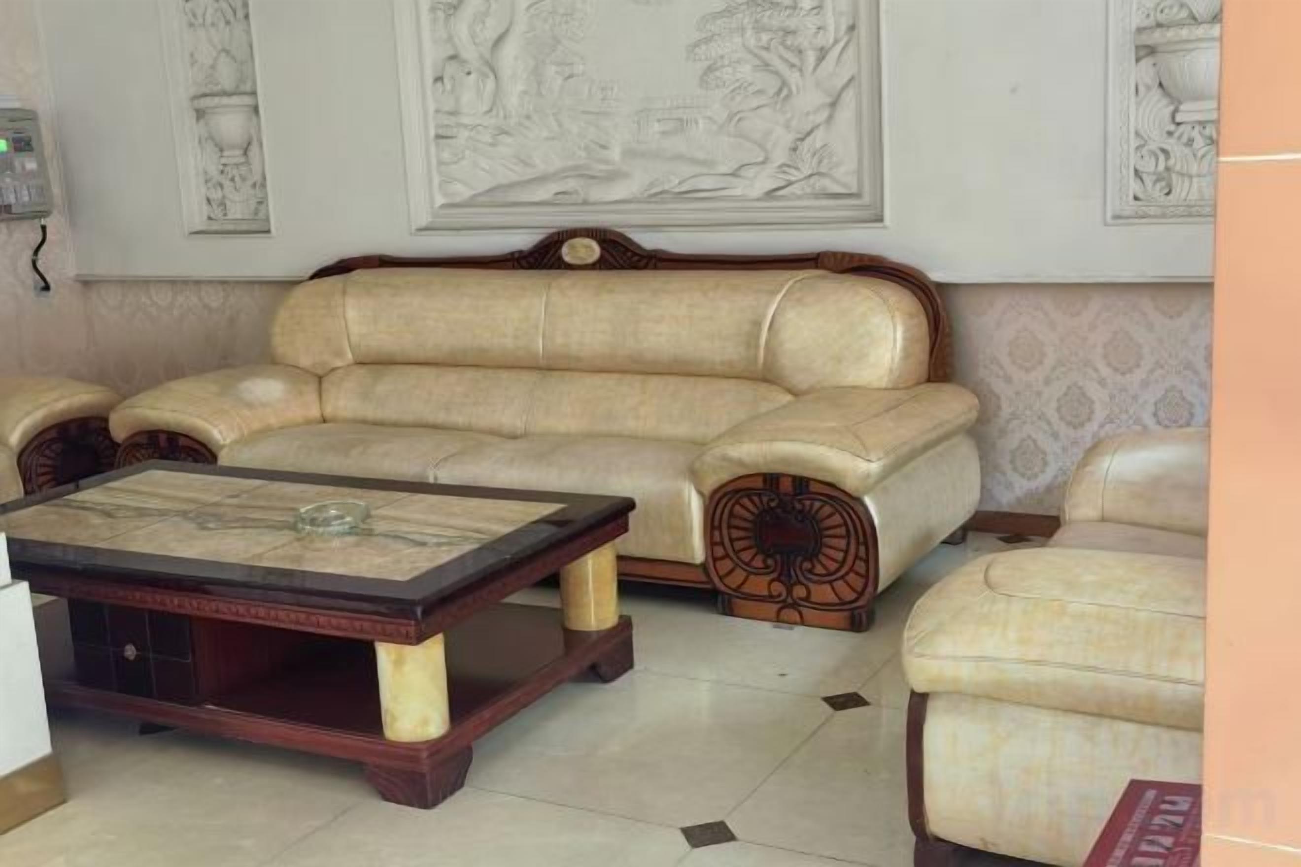 Una sala de estar con un sofá, una mesa de centro y un sillón.