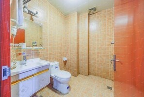 A bathroom with a sink, toilet, and shower. - Yanling Hotel (Meizhou)