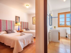 Habitació d'hotel amb dos llits, un bany i una finestra.