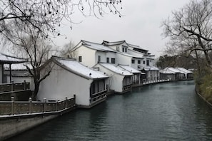 Un edificio tradicional con techo a dos aguas, un canal y un puente de madera.
